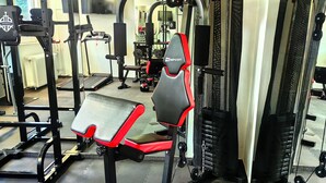 Ett gym med olika typer av träningsutrustning, inklusive styrketräningsmaskiner och löpband.