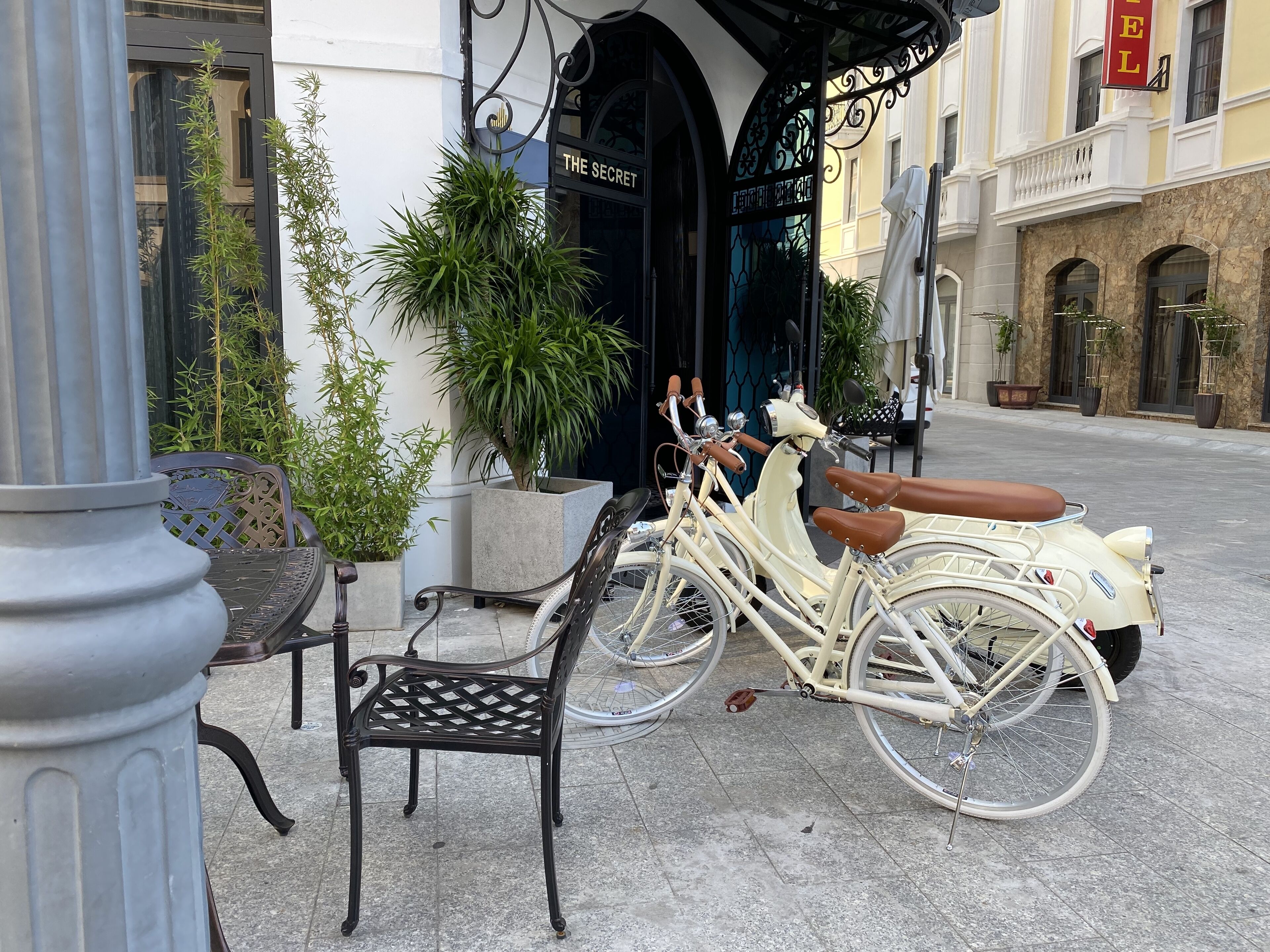 A vintage scooter parked outside a building with a sign reading "THE SECRET."