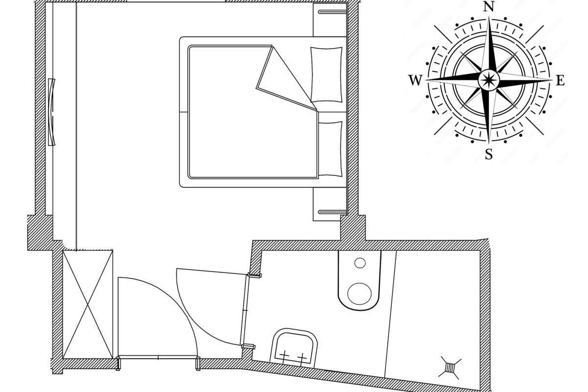 Plano de planta que muestra una habitación central grande, una habitación más pequeña con pared curva y un baño.
