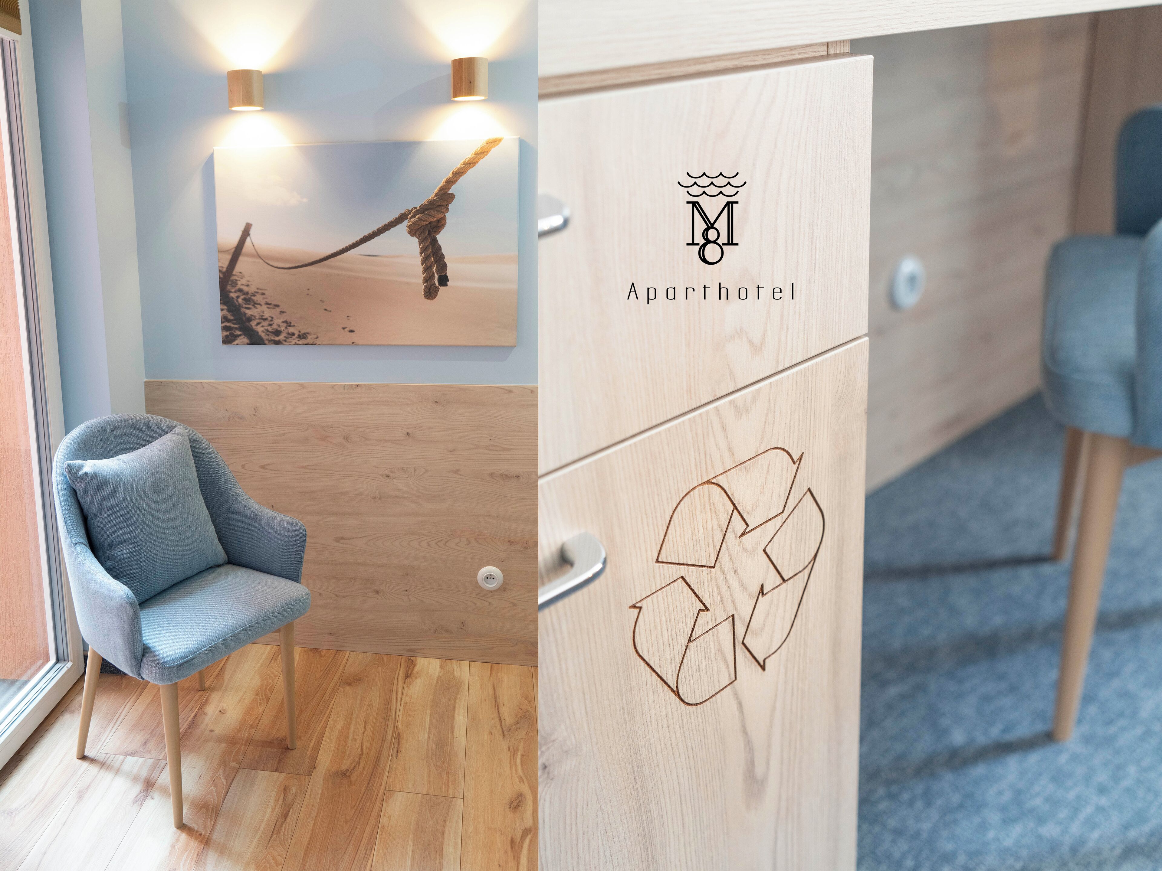 A room with a wooden floor, a blue armchair, a wall-mounted artwork, and a cabinet with a recycling symbol.