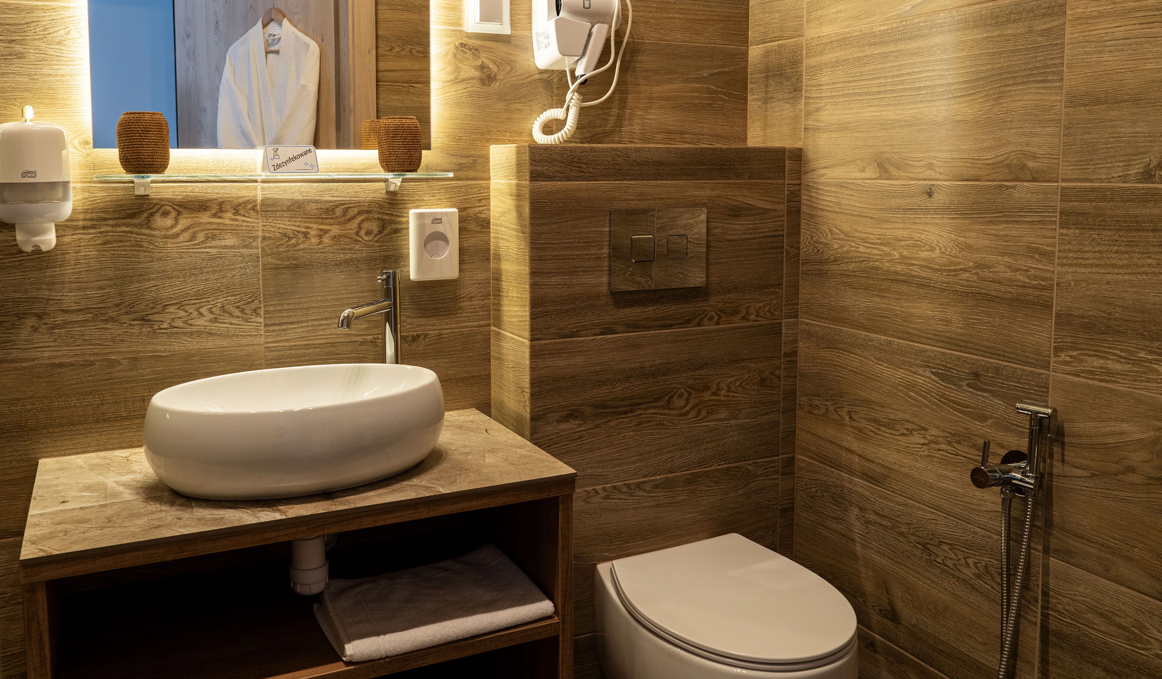 A modern bathroom with a large oval sink, a toilet, and a shower area.
