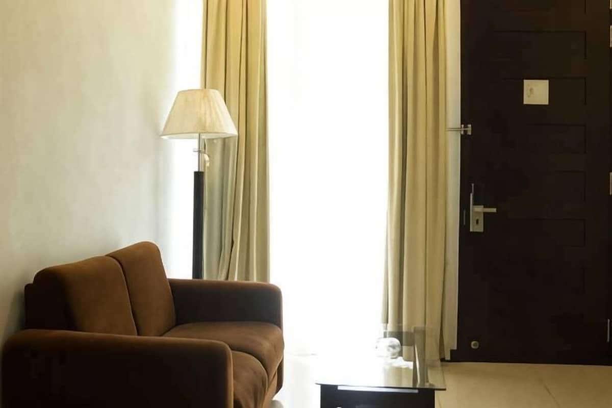 Una habitación con un sofá, una lámpara y una puerta.