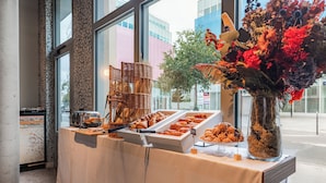 Una mesa de buffet con diversas opciones de pastelería y un jarrón decorativo.