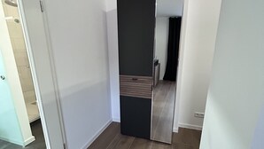 Une pièce spacieuse dotée d’une grande porte coulissante donnant sur une autre pièce, d’un plancher en bois et de murs blancs.