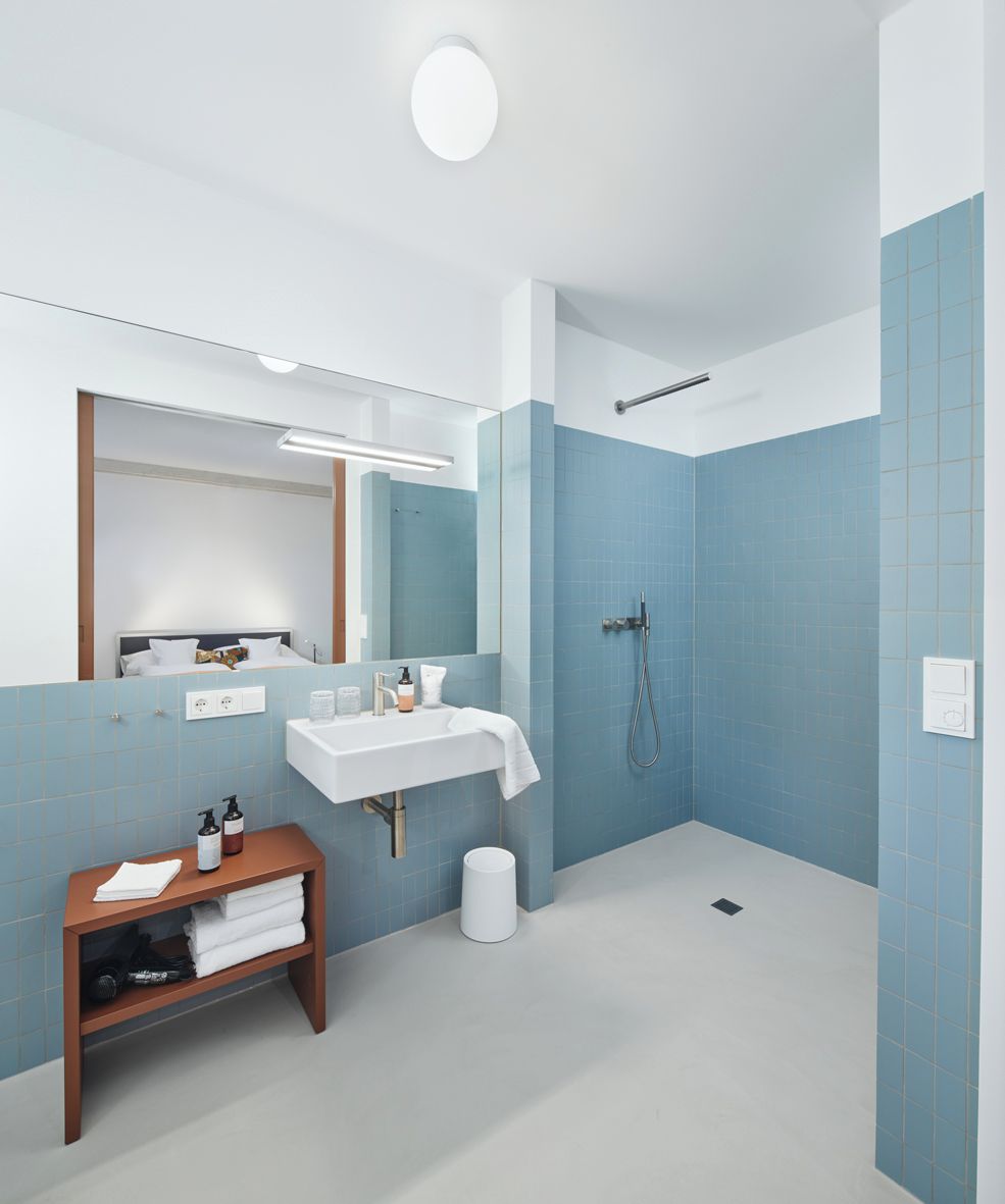 A modern bathroom with a shower, sink, and mirror.