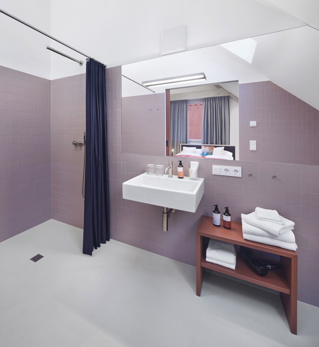 Un baño moderno con ducha, lavamanos y espejo.