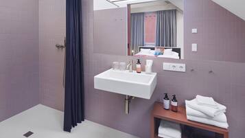 Un baño moderno con ducha, lavamanos y espejo.