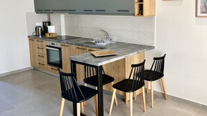 Una cucina moderna con pensili grigi, un lavello in acciaio inossidabile e un'isola in legno con sedie.