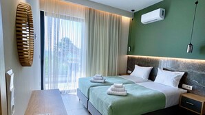 Una camera d'albergo moderna con un letto grande, comodini, una scrivania e una finestra con tende.