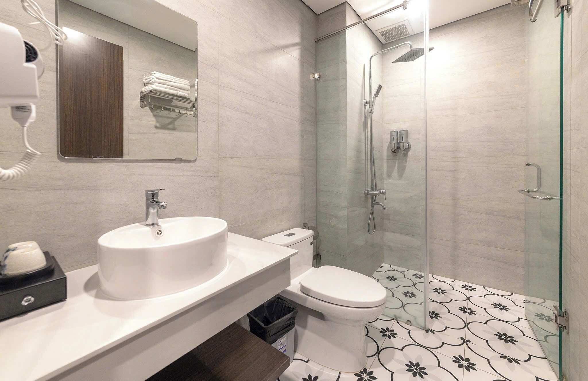 A modern bathroom with a sink, toilet, and glass-enclosed shower.