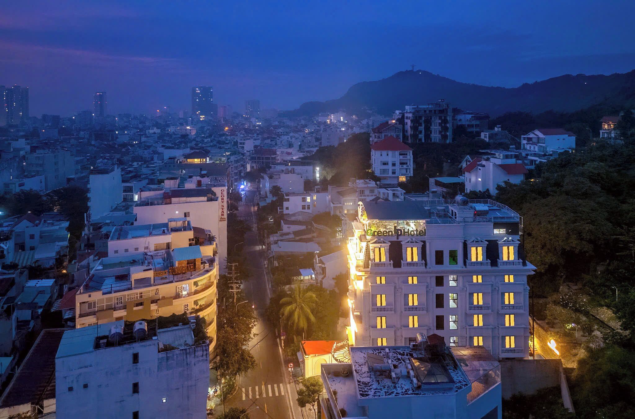 Un hotel con varios pisos, una entrada destacada y vistas de la ciudad circundante.