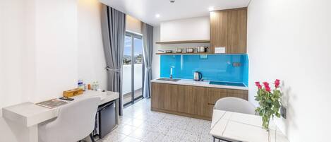 A modern kitchen with a blue backsplash, wooden cabinets, and a dining area with a white table and chairs.