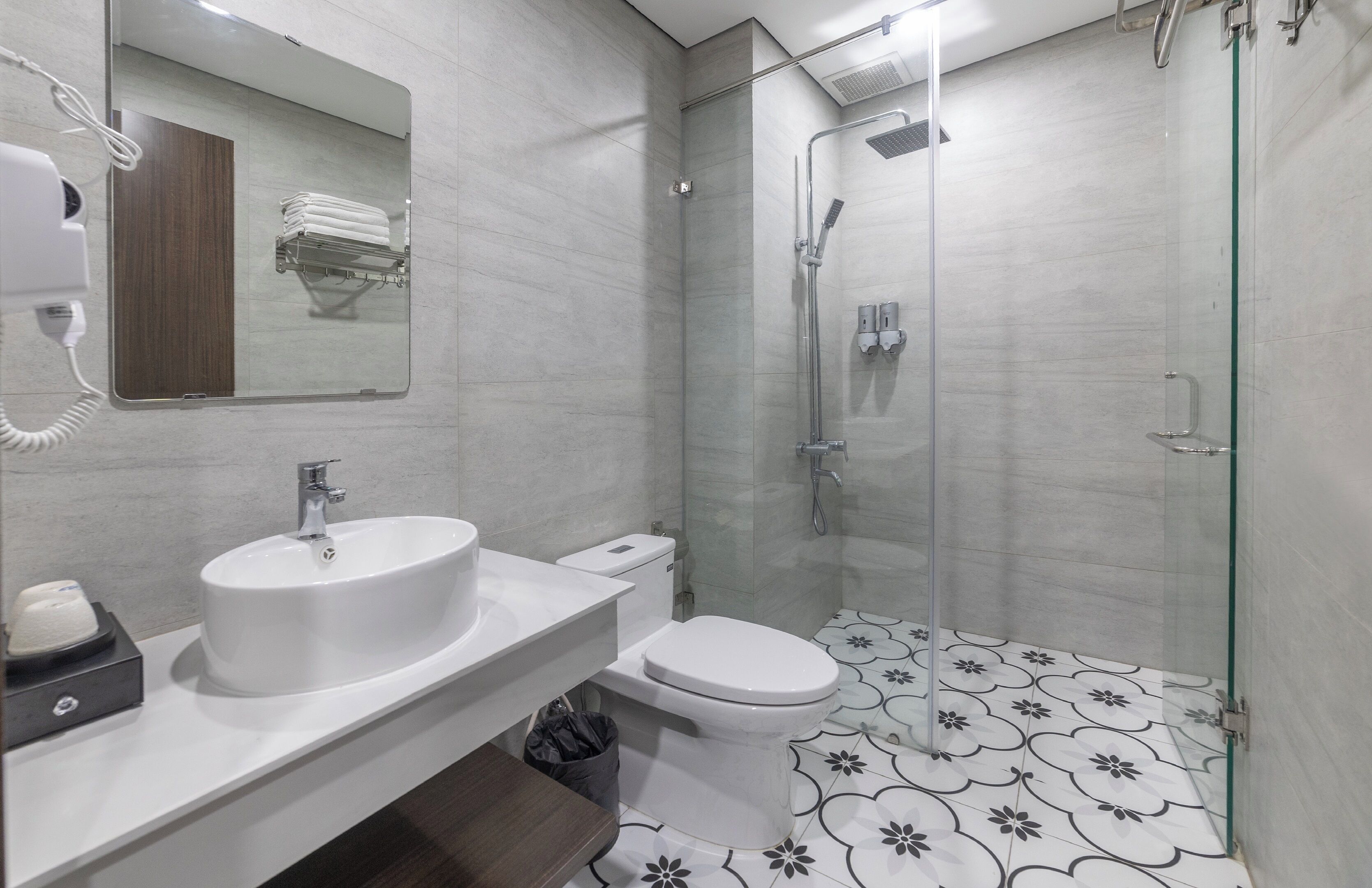 A modern bathroom with a sink, toilet, and glass-enclosed shower.