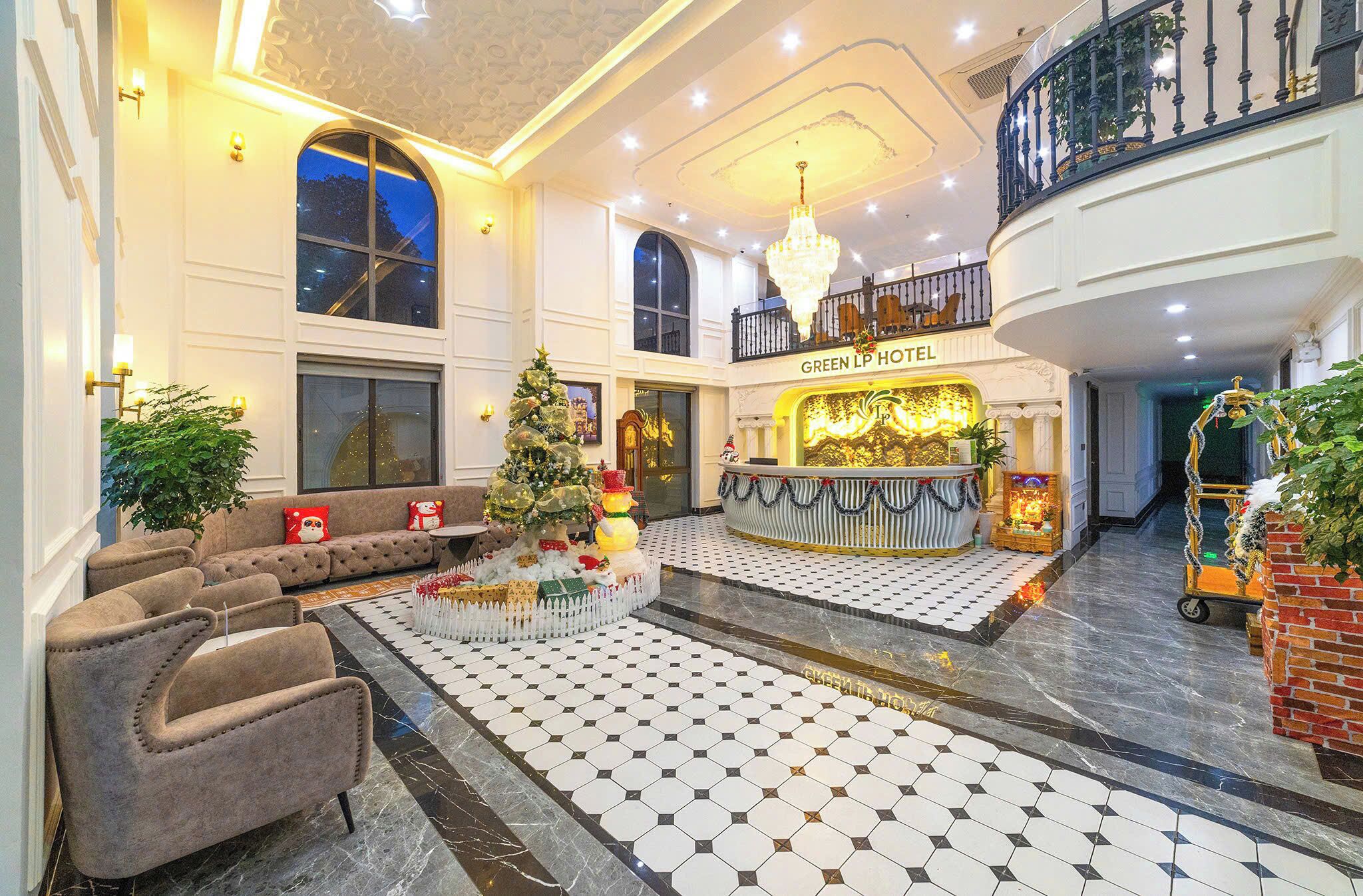 A spacious lobby with a checkered floor, a Christmas tree, and a reception desk labeled "GREEN LP HOTEL".