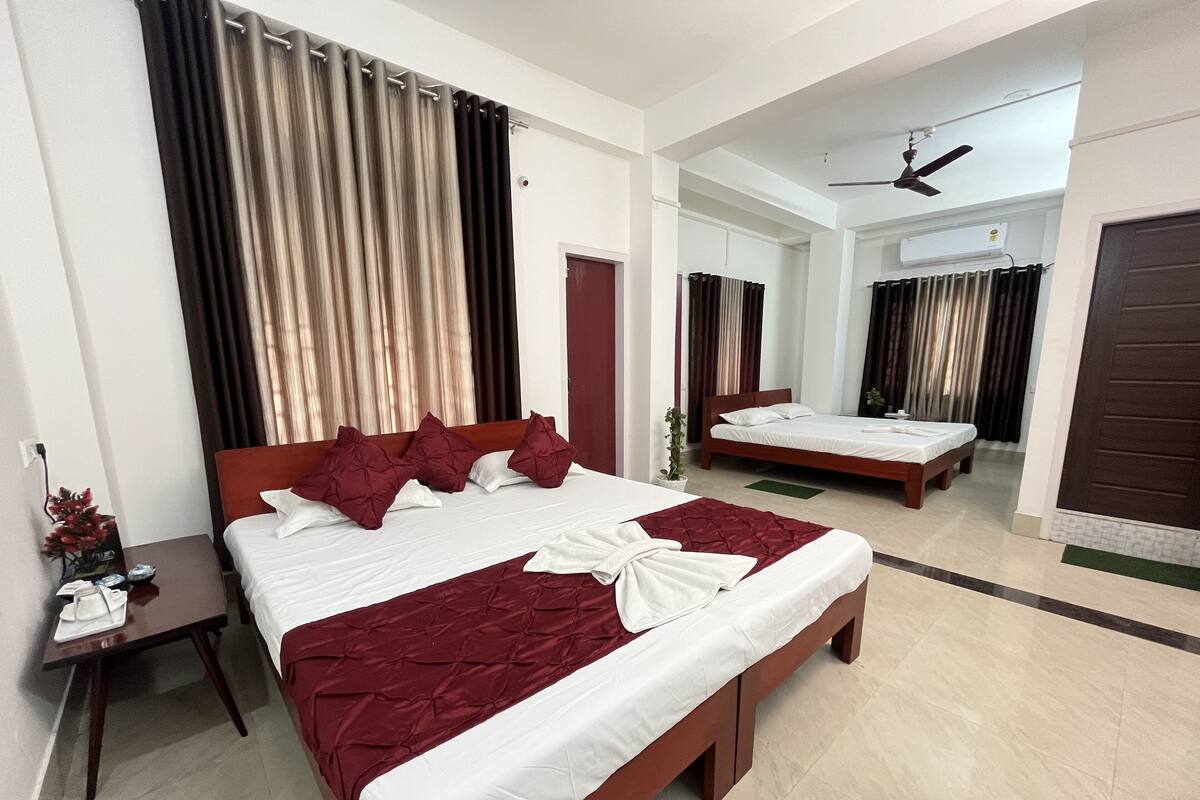 A hotel room with a large bed, a bedside table, a mirror, and a ceiling fan.