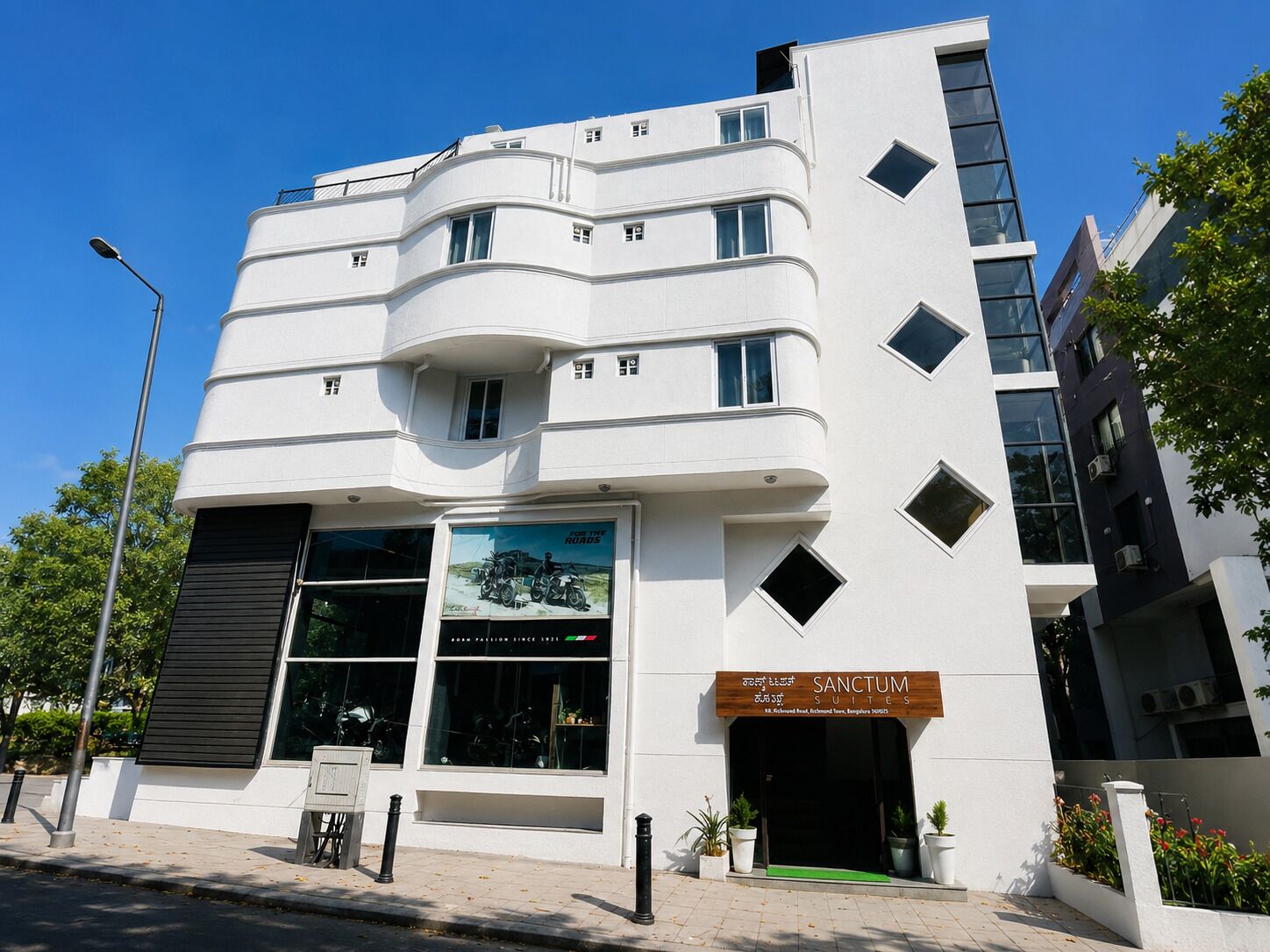 Un bâtiment moderne doté d’une grande vitrine qui fait la publicité de « SANCTUM SUITES ».