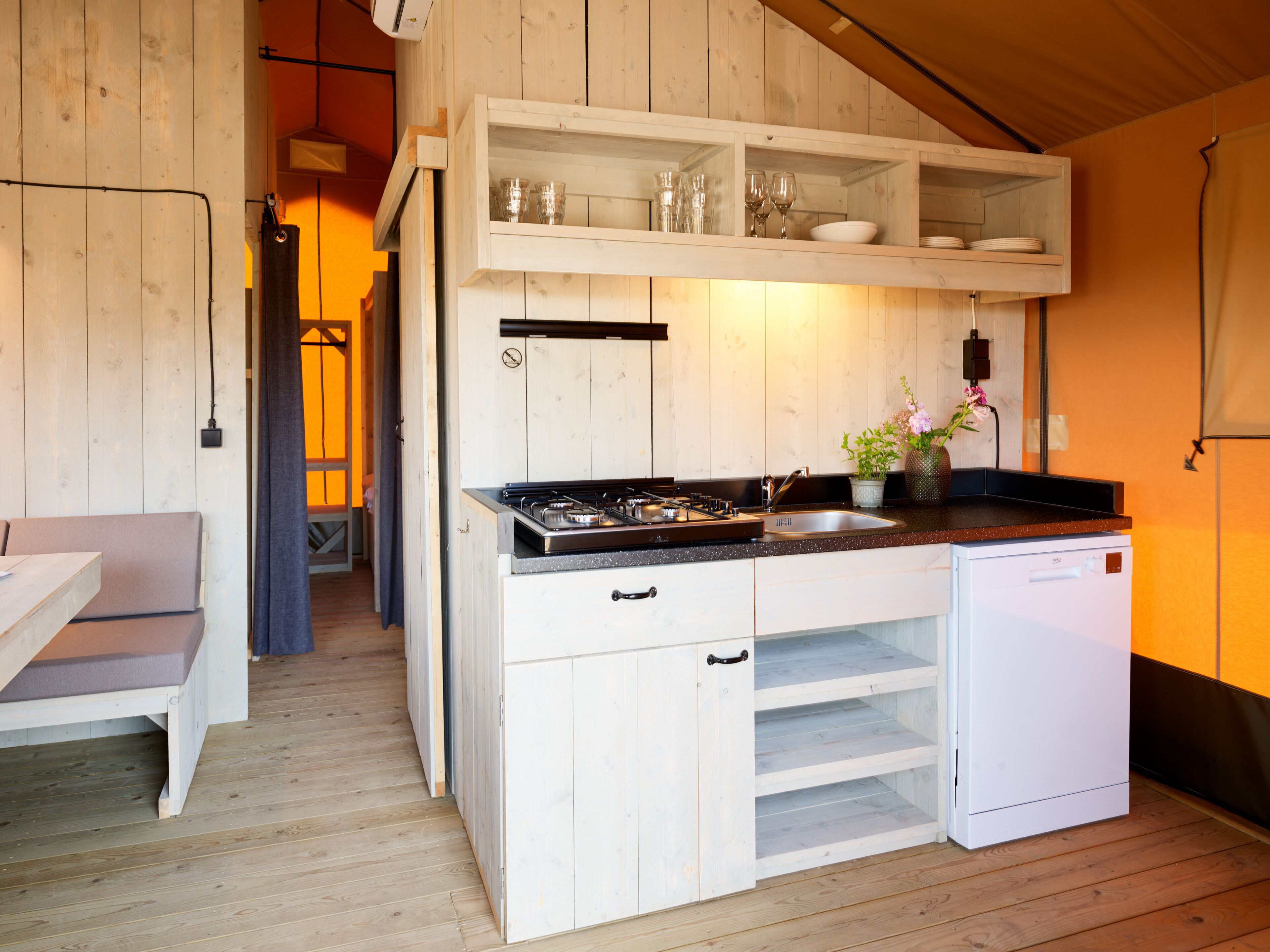 Una cocina compacta con armarios de madera, estufa integrada y un lavabo.