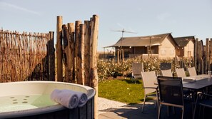 Relax in a serene outdoor setting with a hot tub, dining area, and beautiful views.