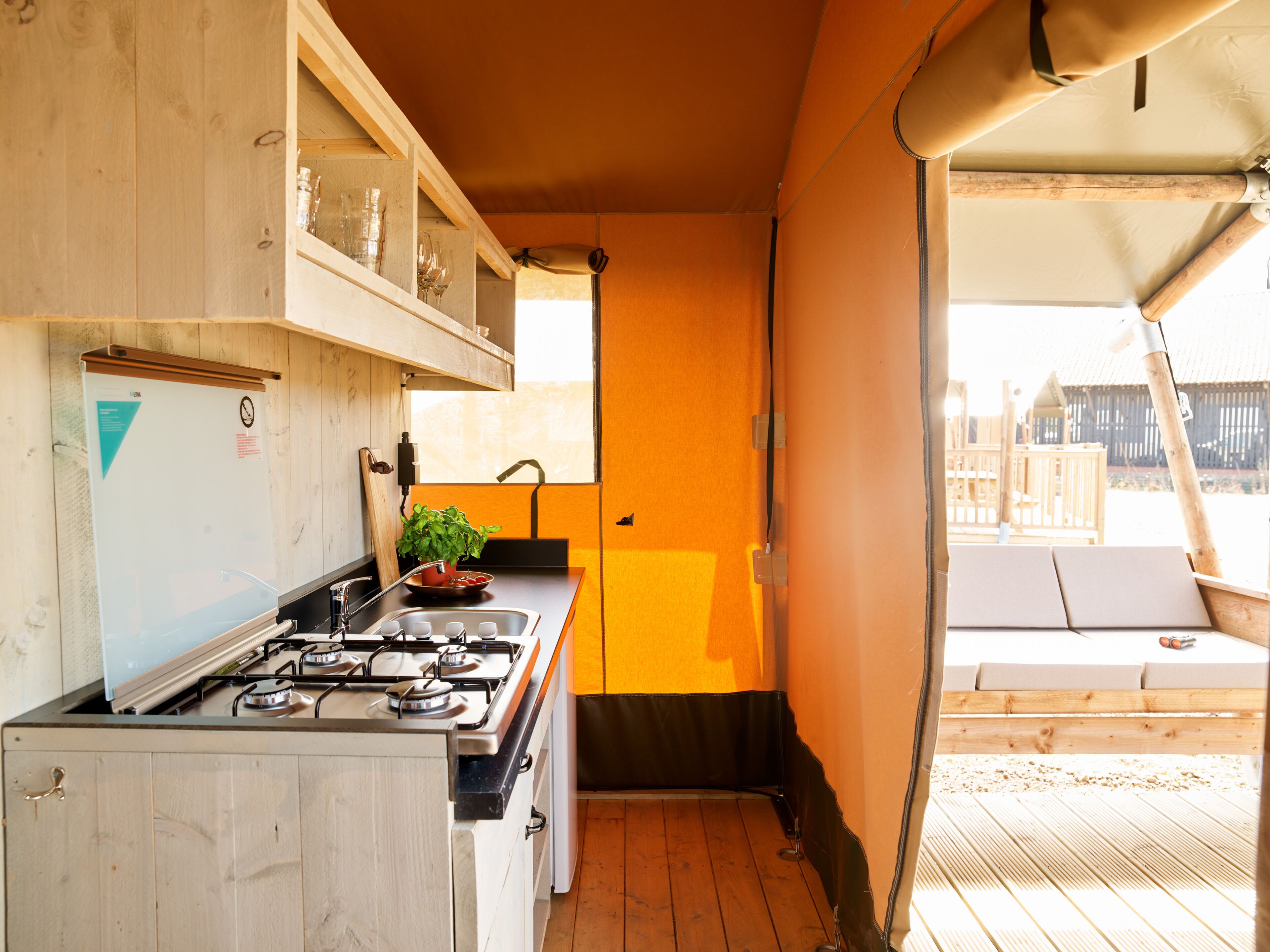 A compact kitchen with a gas stove, a sink, and a window.