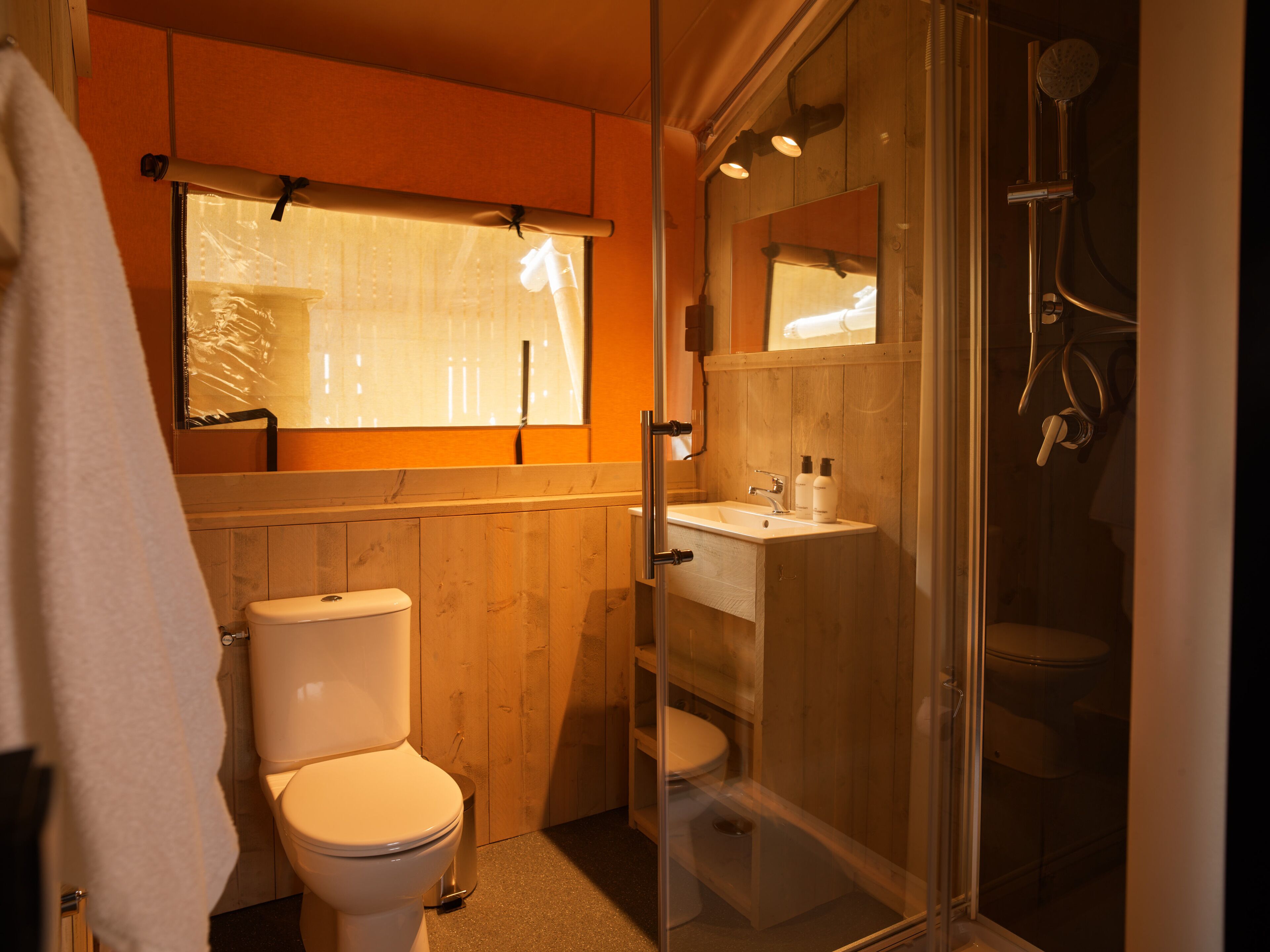 Un baño con inodoro, lavamanos y ducha.