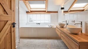 Enjoy a refreshing soak in the bathtub, surrounded by a skylight view of the outdoors.