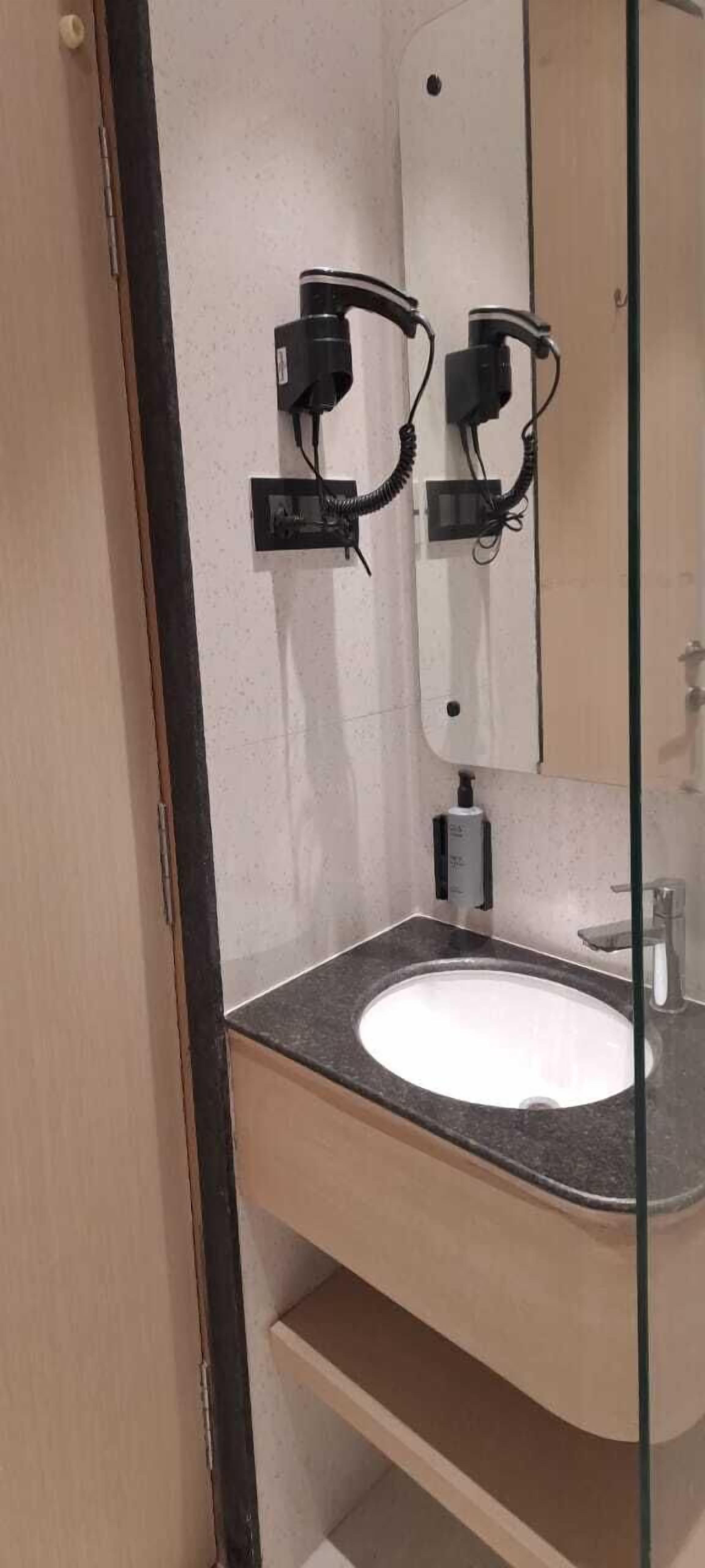 A bathroom with a white sink, a mirror, and a towel rack.