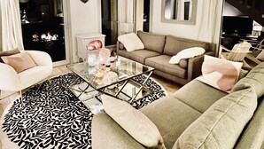 A living room with a sofa, a glass coffee table, and a patterned rug. - Villa with swimming pool in the heart of Provence, in a half-hectare park (Ménerbes)