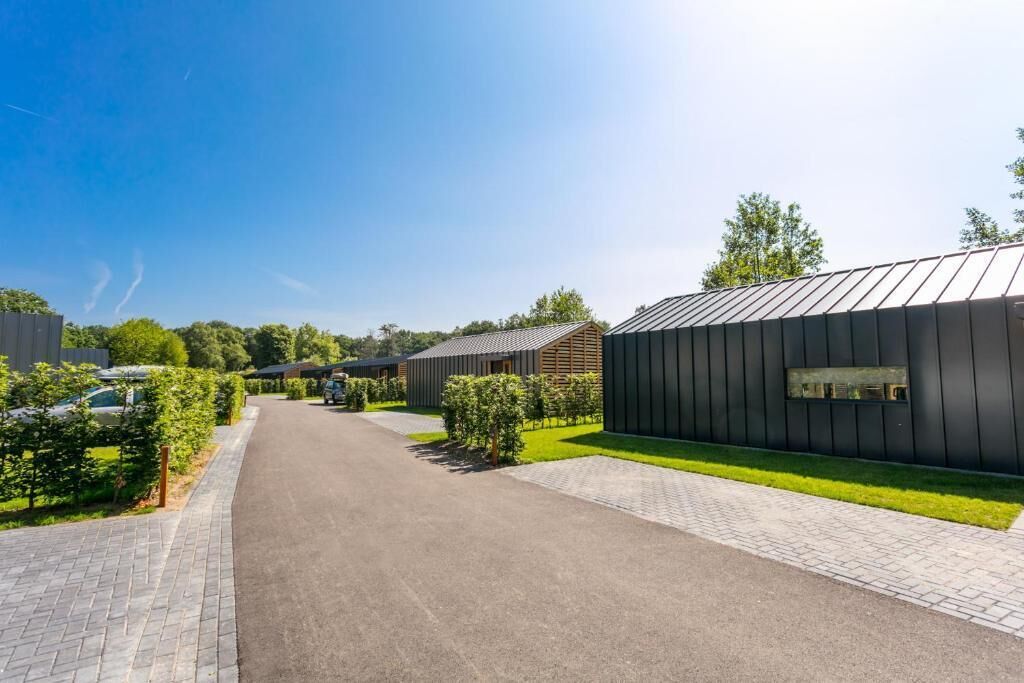 Un bâtiment moderne doté d’une allée pavée et d’un espace verdoyant.