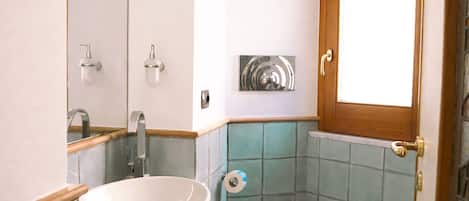 A compact bathroom with a white sink, a toilet, and a mirror.