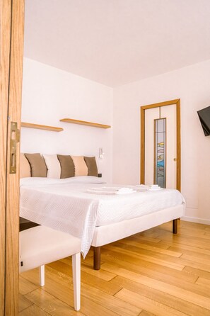 A neatly arranged bedroom with a bed, bedside tables, and a mirror. - Residenza Ester (Amalfi)
