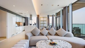 Ein modernes Wohnzimmer mit Sofa, Couchtisch und Essbereich, gedeckt für zwei Personen.