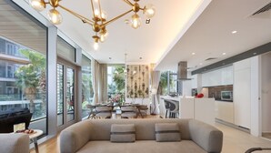 Una sala de estar moderna con un sofá grande, comedor y cocina.
