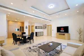 Relax in this stylish living space with a flat-screen TV, dining area, and comfortable seating.