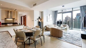 Een moderne woonkamer met een eethoek, een bank en een groot raam met uitzicht op de stad.