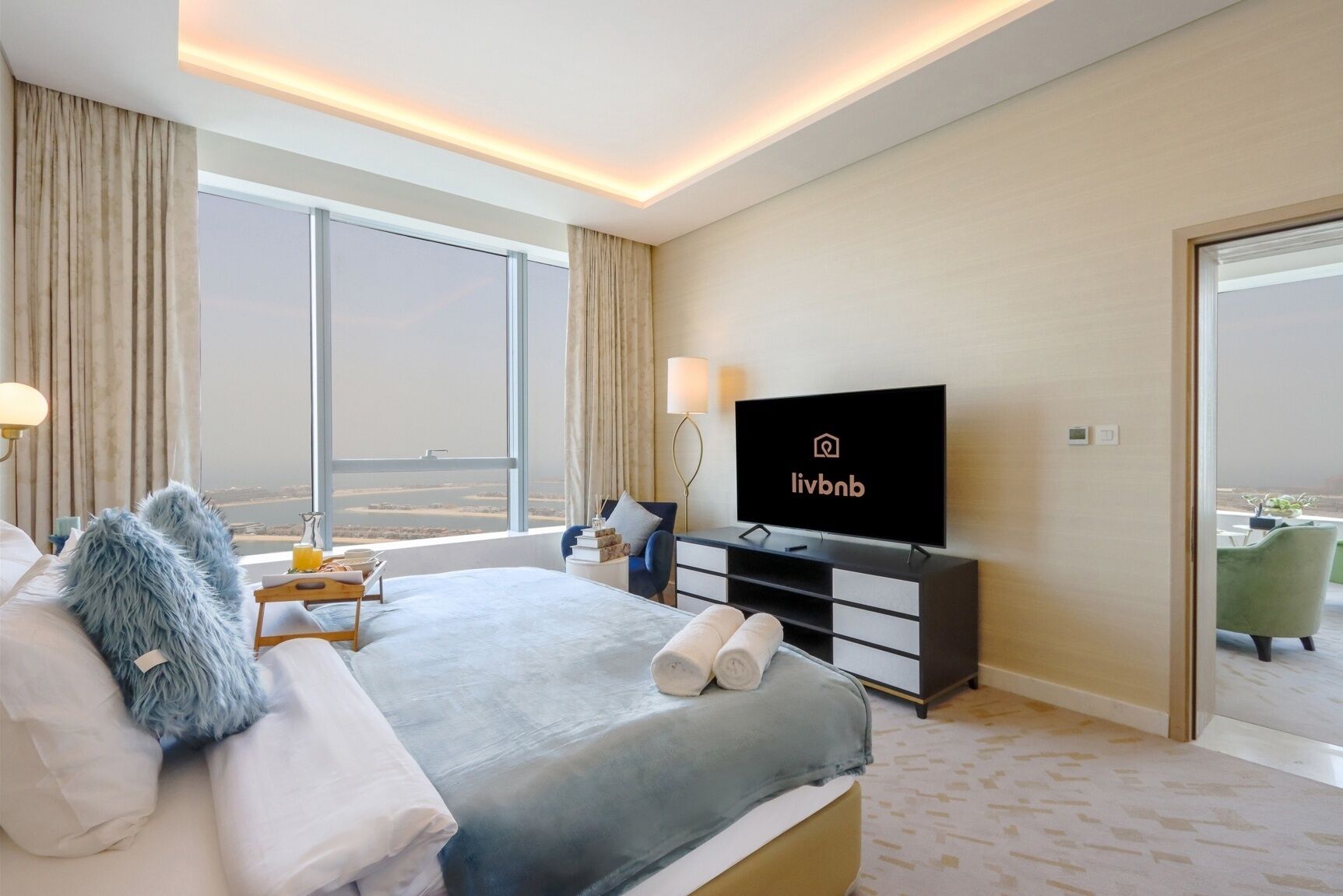 Une chambre d’hôtel moderne dotée d’un grand lit, d’une télévision à écran plat, d’une vue sur la ville et d’un balcon.