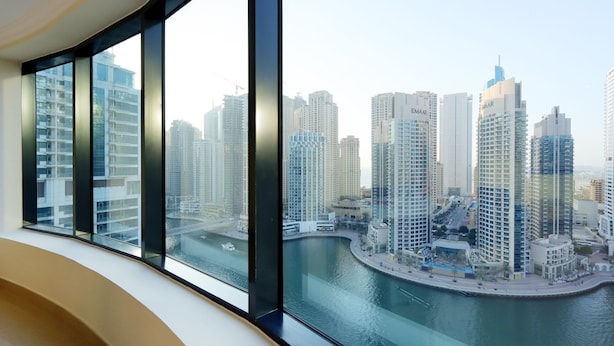 Um edifício alto com vista para um horizonte urbano e um corpo de água.
