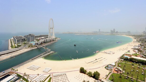 A coastal resort with a beach, a Ferris wheel, and a marina.