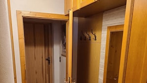 En hall med träskåp och en bänk.