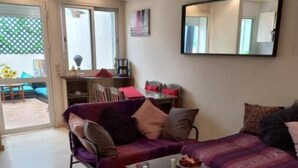A living room with a sofa, a coffee table, and a dining area with chairs and a table. - Star Studio Gauthier (Casablanca)