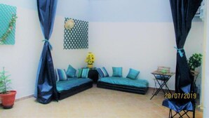 A room with a corner sofa, a small table, a potted plant, and a curtain. - Star Studio Gauthier (Casablanca)