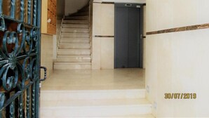 A staircase leading to a dark door, with a metal gate on the left. - Star Studio Gauthier (Casablanca)