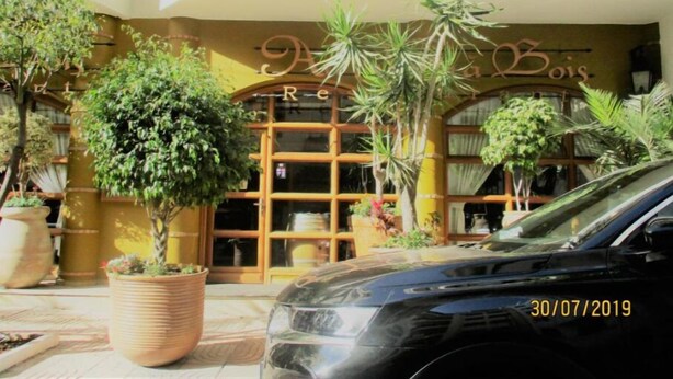 A building with a sign that reads "RECE" and "Bois". There are potted plants in front of the building. - Star Studio Gauthier (Casablanca)
