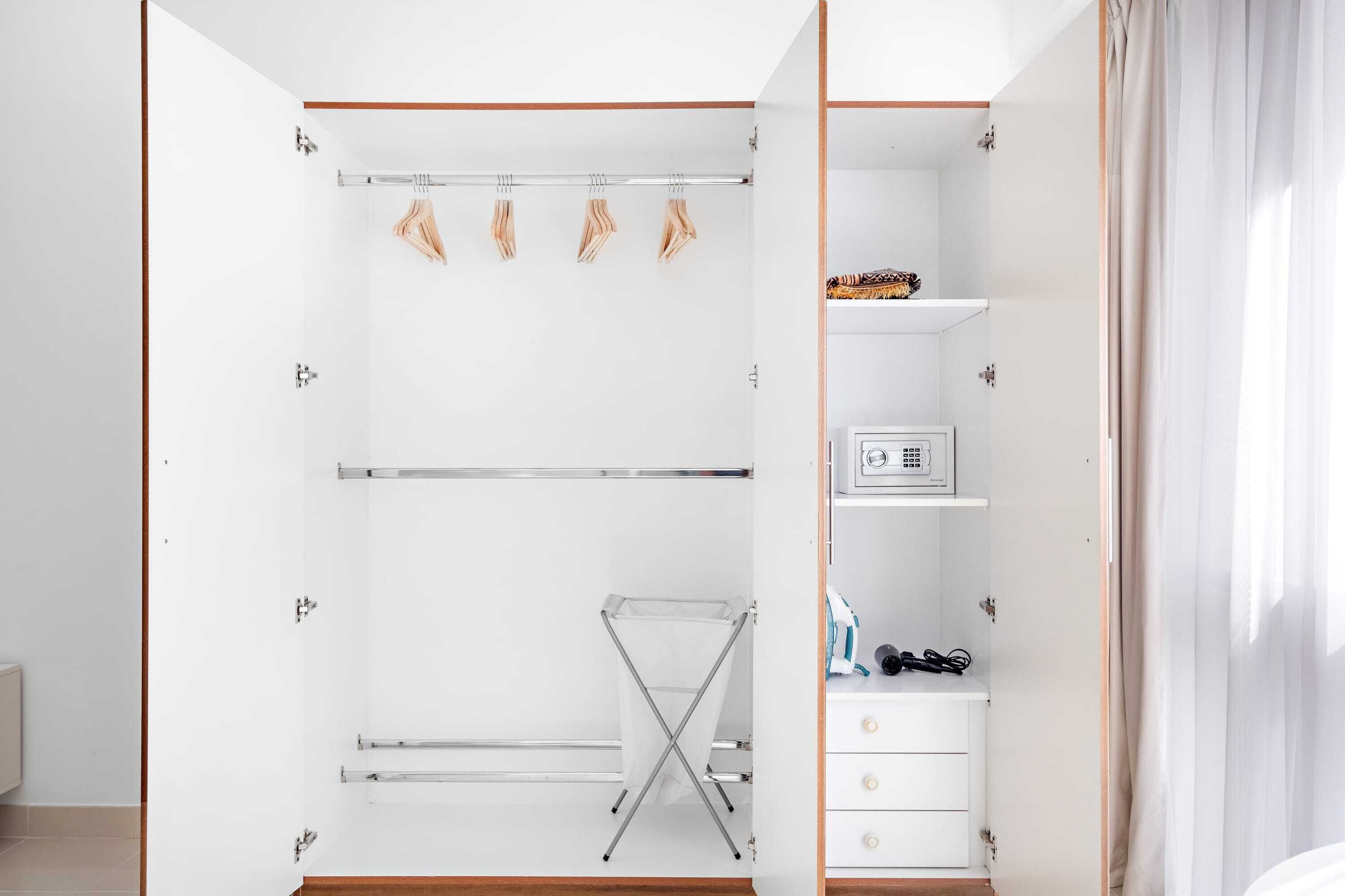 A walk-in closet with open shelves, a drying rack, and a small white cabinet.