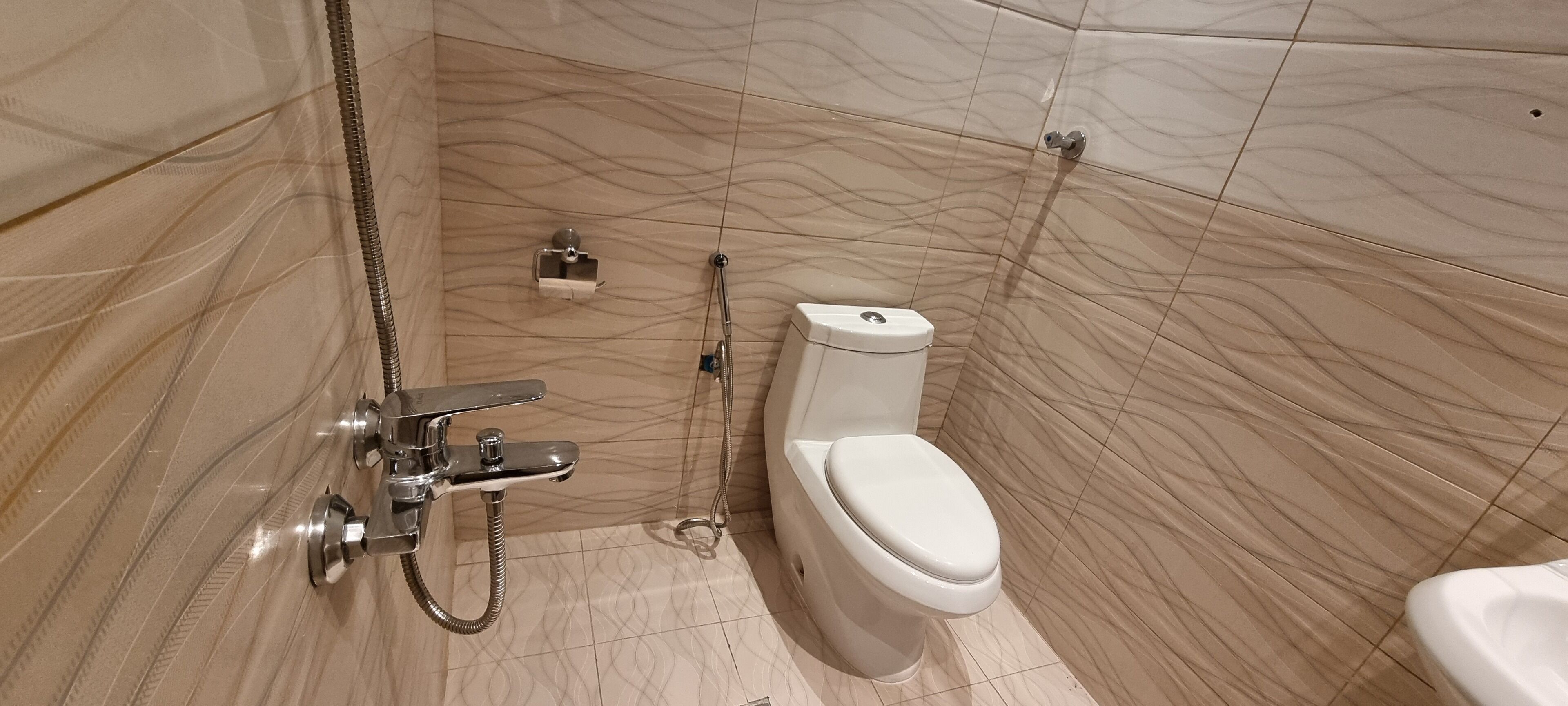 A bathroom with a toilet, a shower, and a sink.