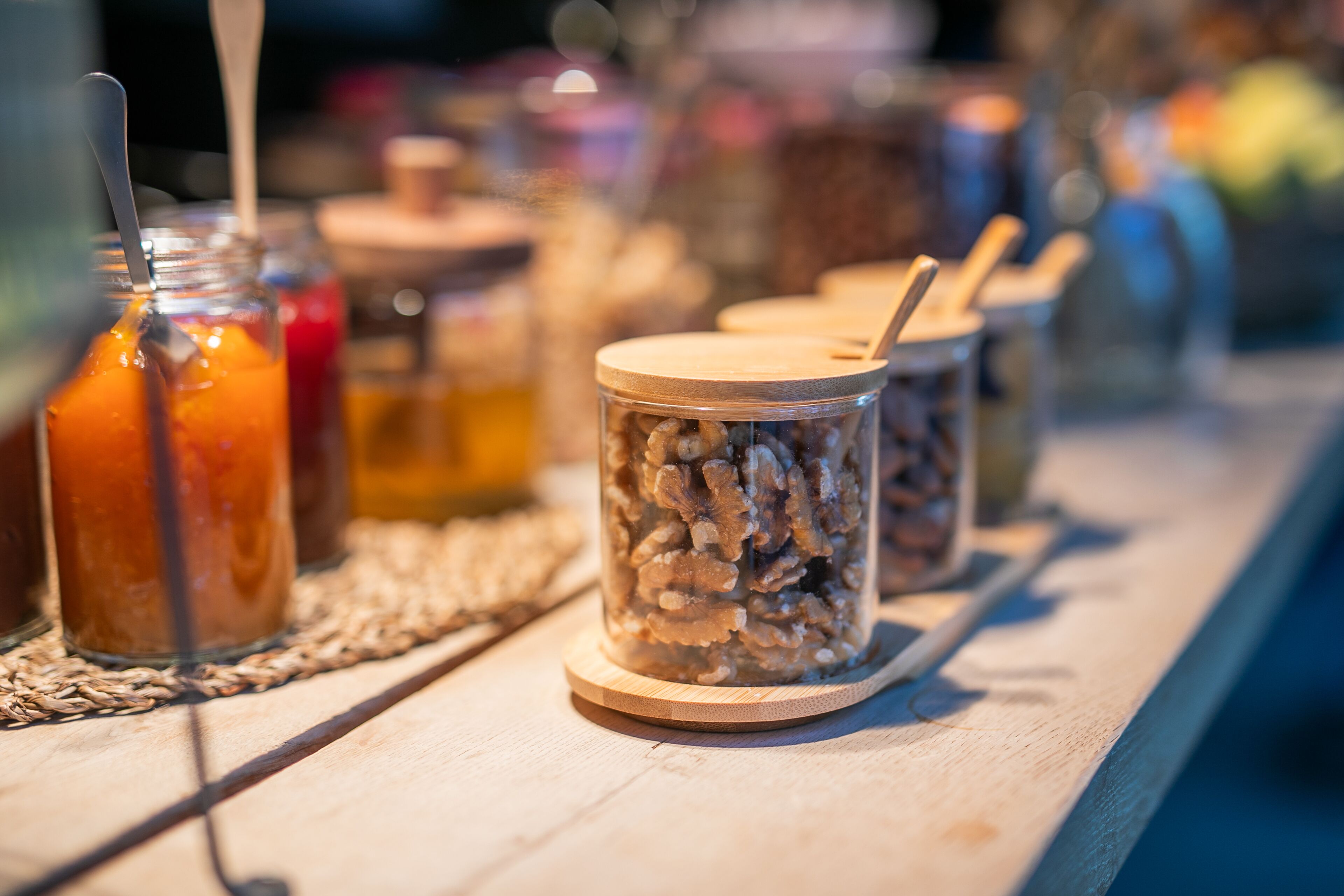 A wooden table with jars containing various food items and utensils.