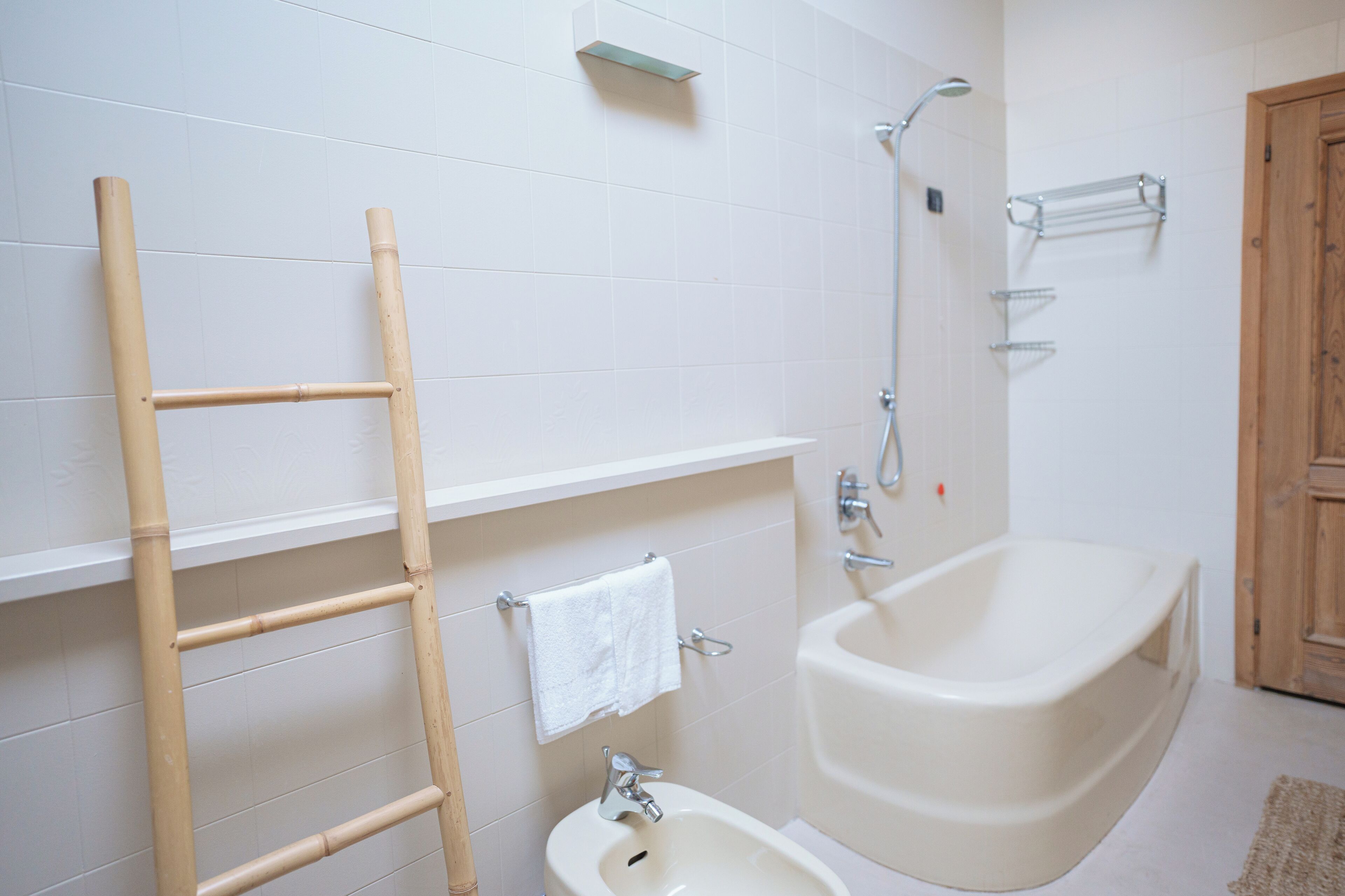 Ein Badezimmer mit einer Badewanne, einer Dusche, einer Toilette und einem Handtuchhalter.