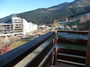 A hotel with multiple floors, a ski lift in the background, and a mountainous landscape. - Studio cabin at the foot of the slopes - 2nd floor - Les Adrets-Prapoutel (Les Adrets-Prapoutel)