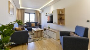 Ein modernes Wohnzimmer mit einer Couch, einem Couchtisch und einem an der Wand montierten Fernseher.