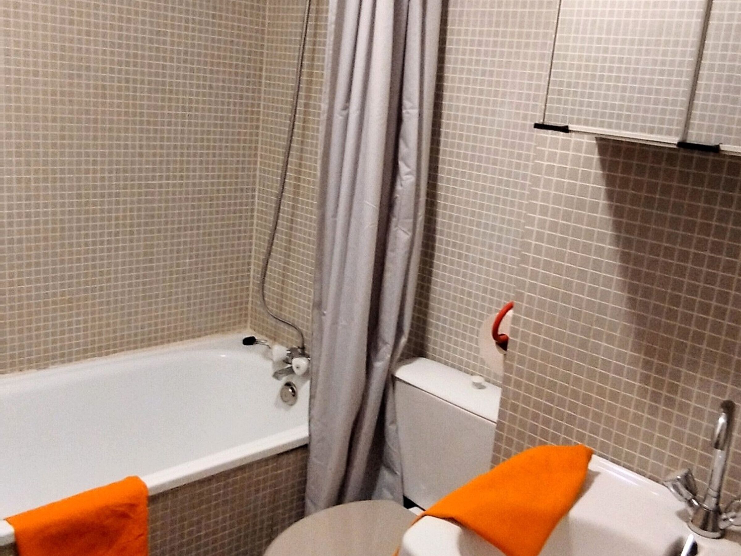 A bathroom with a bathtub, toilet, and sink.