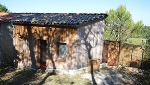 A small wooden building with a tiled roof, two windows, and a door.